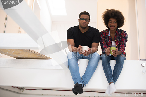 Image of couple having break during moving to new house