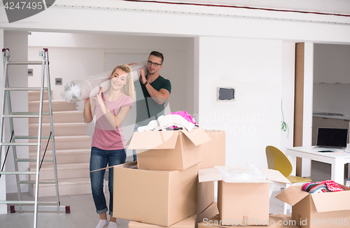 Image of couple carrying a carpet moving in to new home