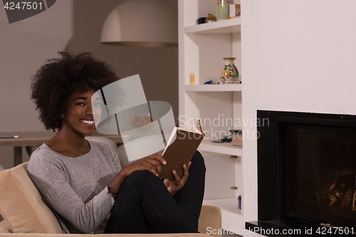 Image of black woman at home reading book