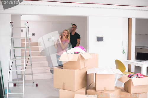 Image of couple carrying a carpet moving in to new home