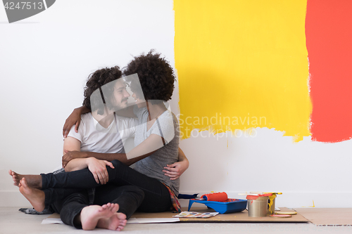 Image of young multiethnic couple relaxing after painting
