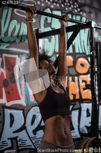 Image of black woman doing pull ups