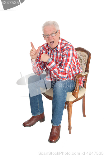 Image of Senior man sitting surprised.