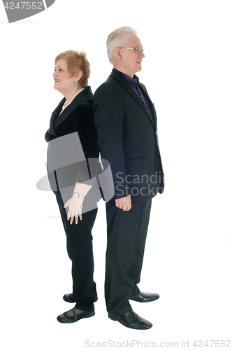 Image of Senior couple standing back to back.