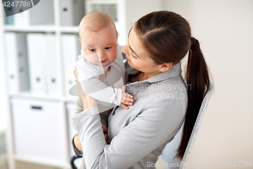 Image of happy businesswoman with baby at office