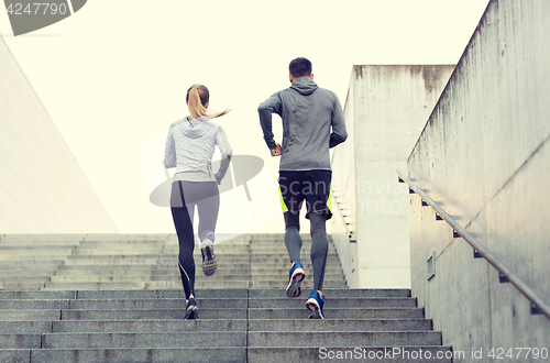 Image of couple running upstairs on city stairs