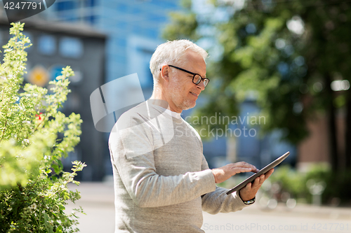 Image of senior man with tablet pc on city street