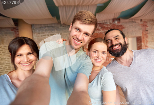 Image of happy friends at yoga studio or gym taking selfie