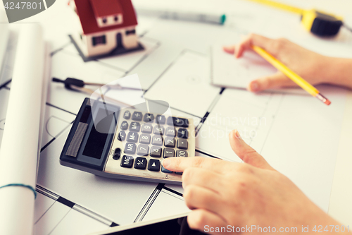 Image of close up of architect hand counting on calculator