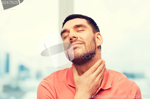 Image of unhappy man suffering from throat pain at home