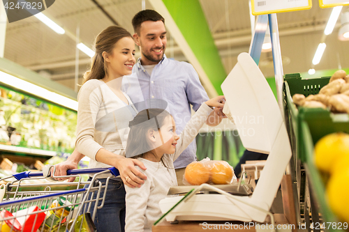 Image of family weighing oranges on scale at grocery store