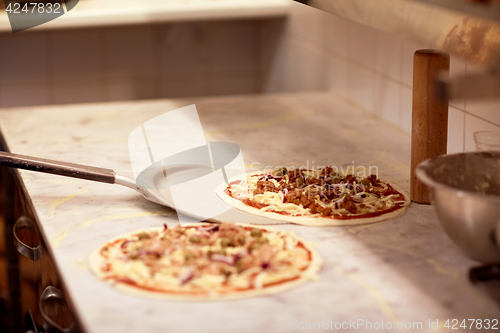 Image of peel taking pizza off table at pizzeria