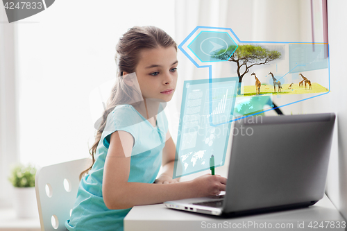 Image of girl with laptop writing to notebook at home