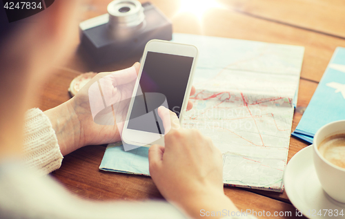 Image of close up of traveler hands with smartphone and map