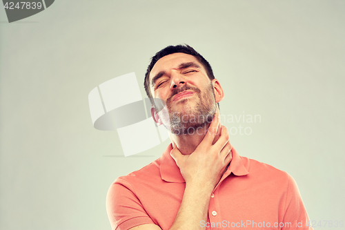 Image of man touching neck and suffering from throat pain