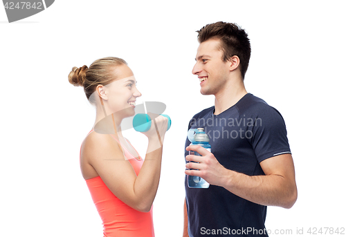 Image of sportive man and woman with dumbbell and water