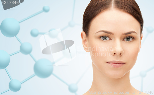 Image of beautiful young woman face with molecules