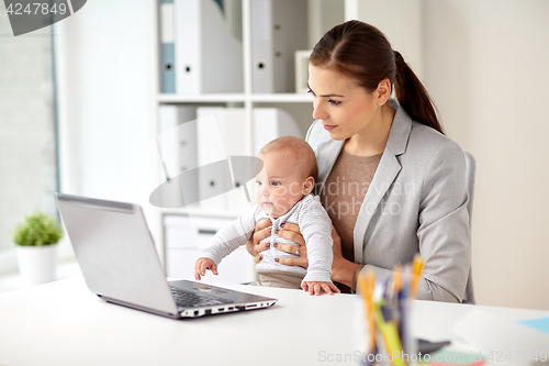 Image of happy businesswoman with baby and laptop at office