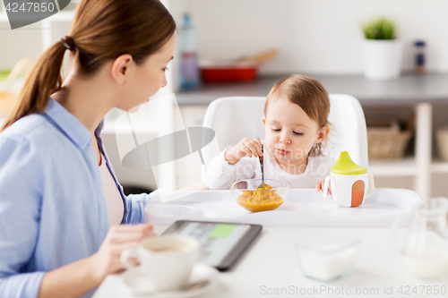Image of happy mother and baby having breakfast at home