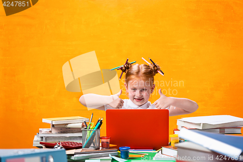 Image of The Redhead teen girl with lot of books at home. Studio shot