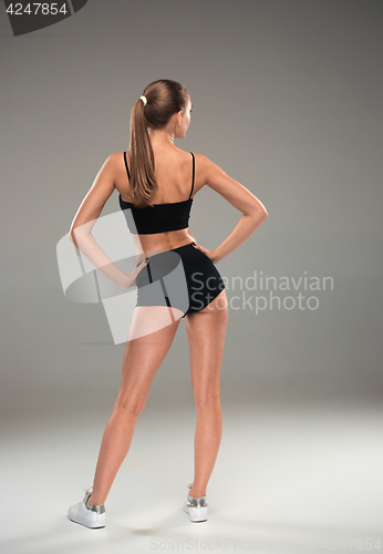 Image of Muscular young woman athlete on gray