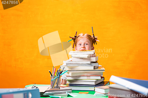 Image of The Redhead teen girl with lot of books at home. Studio shot