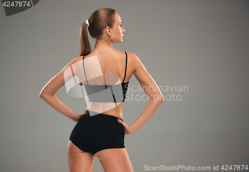 Image of Muscular young woman athlete on gray
