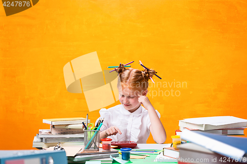 Image of The Redhead teen girl with lot of books at home. Studio shot
