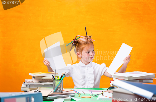 Image of The Redhead teen girl with lot of books at home. Studio shot