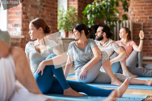 Image of group of people doing yoga exercises at studio