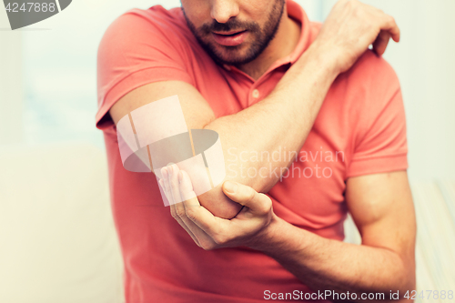 Image of close up of man with injured hand at home