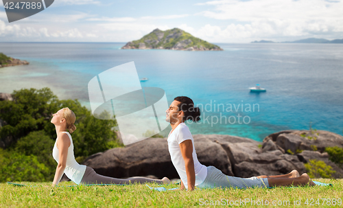 Image of couple making yoga cobra pose outdoors