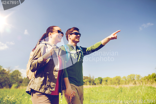 Image of happy couple with backpacks hiking outdoors