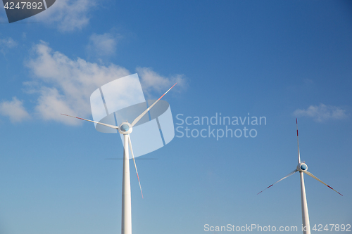 Image of wind turbines over blue sky