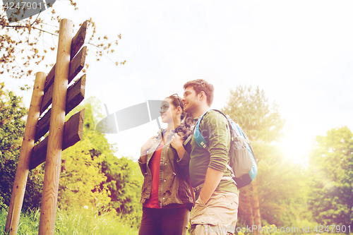 Image of smiling couple with backpacks hiking