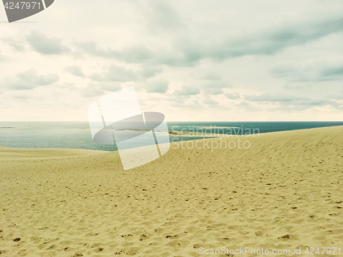 Image of Sand dunes, sea and cloudy sky