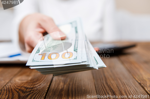 Image of Hands of person proposing money to you - closeup shot