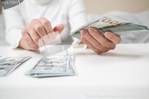 Image of Close up of woman with calculator counting money