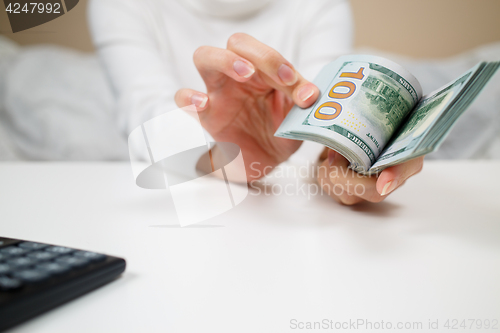 Image of business, finance, saving, banking and people concept - close up of woman hands counting us dollar money