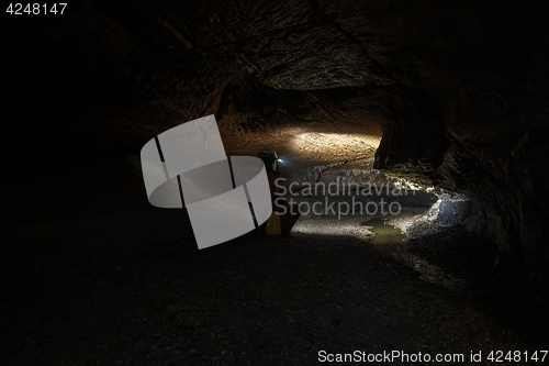 Image of Woman with headlamp inside cave