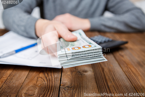 Image of Hands of person proposing money to you - closeup shot