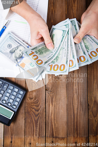 Image of Hands hold and counting us dollar banknotes