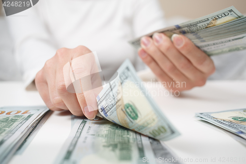 Image of View of woman hands counting money.