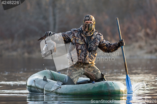 Image of hunter with a duck in a boat