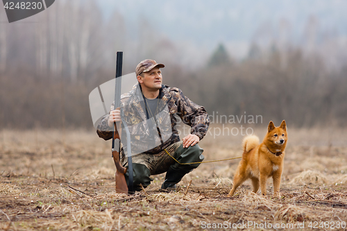 Image of hunter with gun and dog