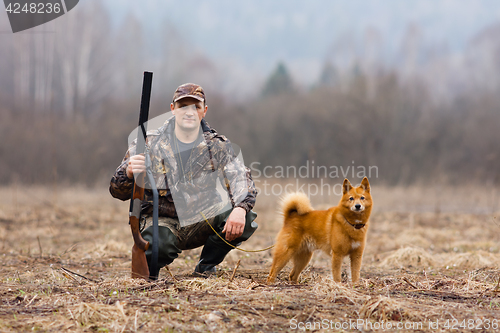 Image of hunter with dog on the field