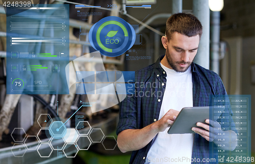 Image of young man with tablet pc and cows on dairy farm