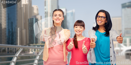 Image of international women showing thumbs up in city