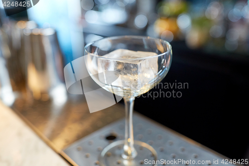 Image of glass with ice cube at cocktail bar