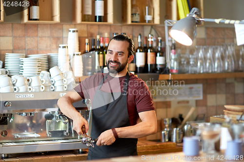 Image of barista with holder and tamper making at coffee